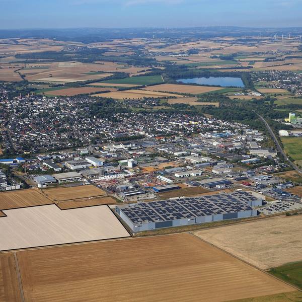 Drohnenansicht des Gewerbegebiets der Stadt Zülpich mit vielen Fabrikhallen und Feldern.