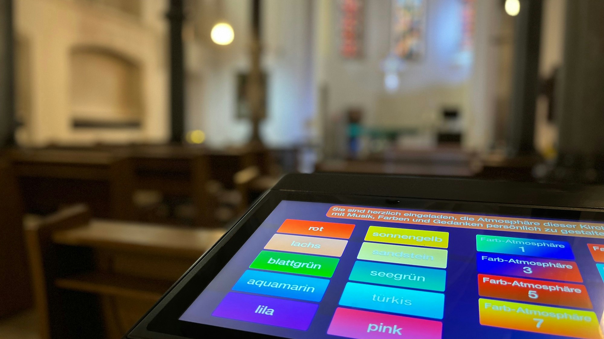 Ein Display mit bunten Feldern steht in einer Kirche.