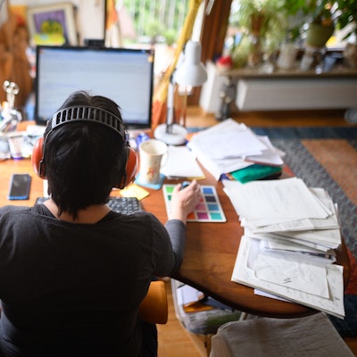 Eine Frau arbeitet mit Hörschutz im Homeoffice.