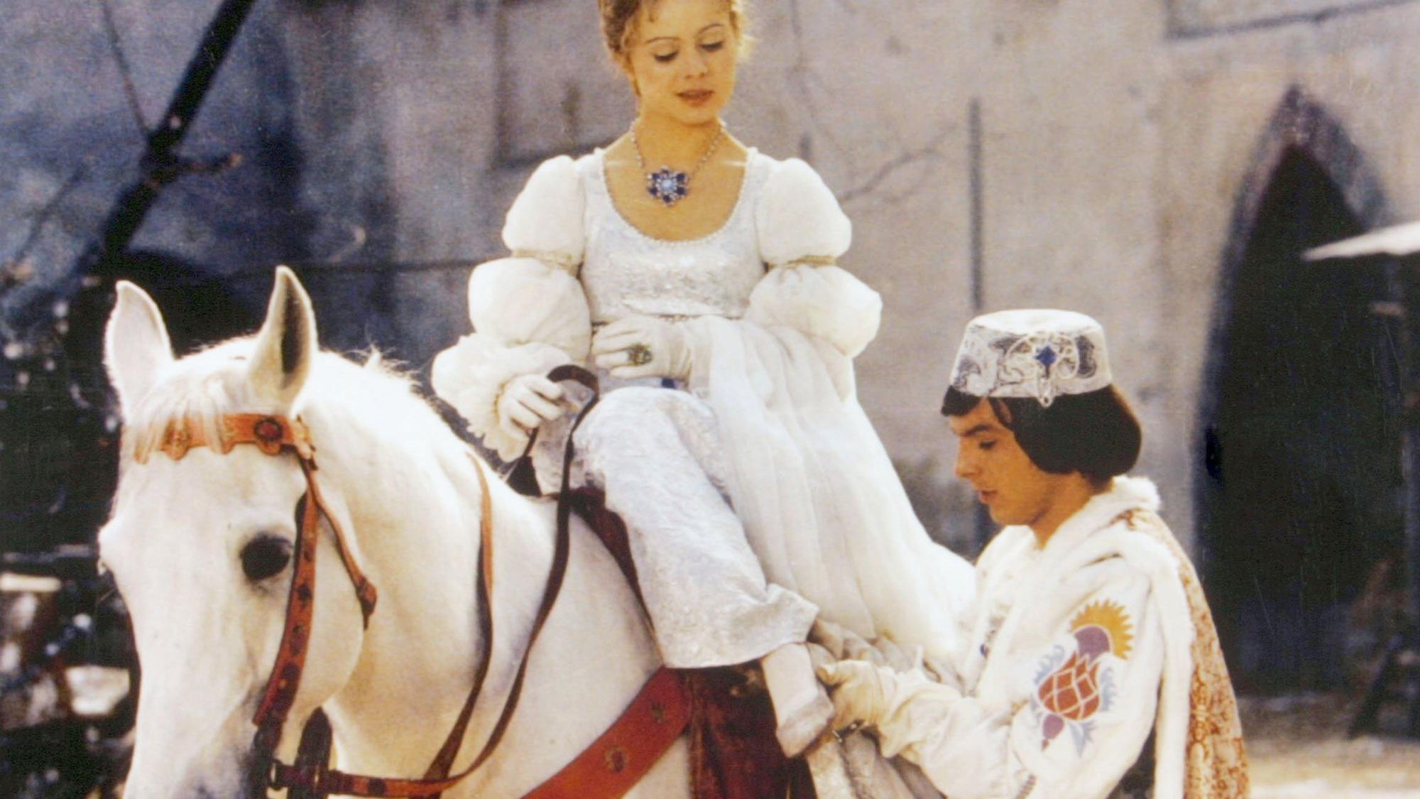 Der Prinz (Pavel Trávnícek) passt Aschenbrödel (Libuse Safránková) den verlorenen Schuh an - eine Szene aus „Drei Haselnüsse für Aschenbrödel“.