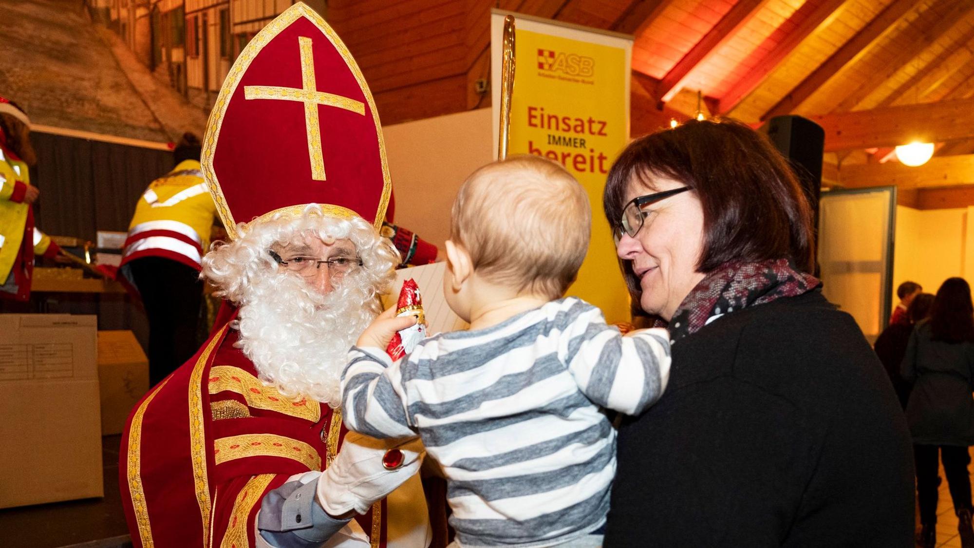 Der Nikolaus beschenkt ein Kind.