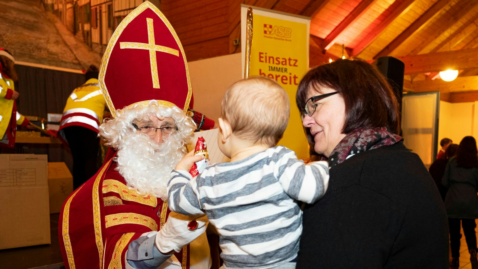 Der Nikolaus beschenkt ein Kind.