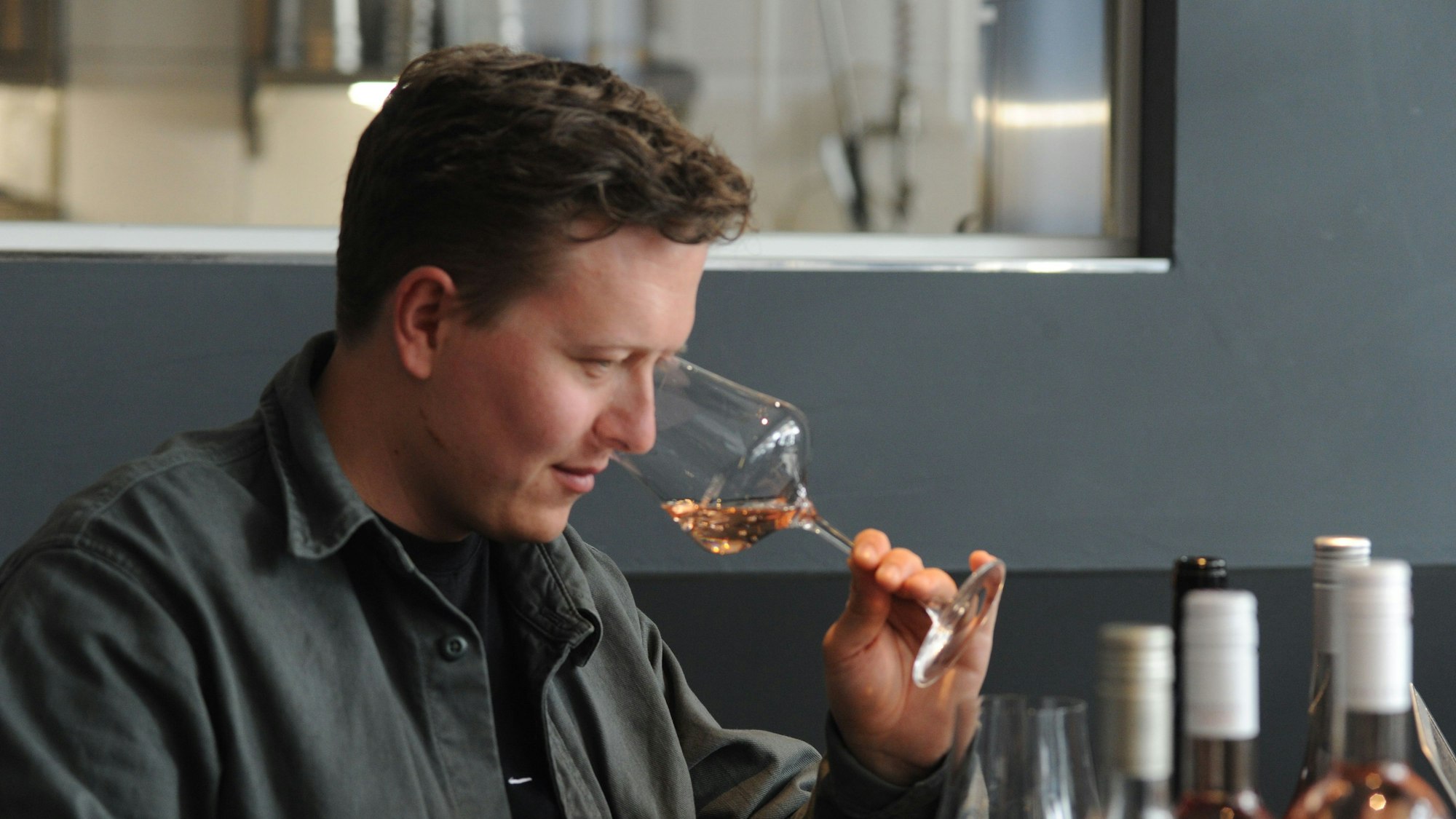 Mann riecht den Roséwein in einem Weinglas.