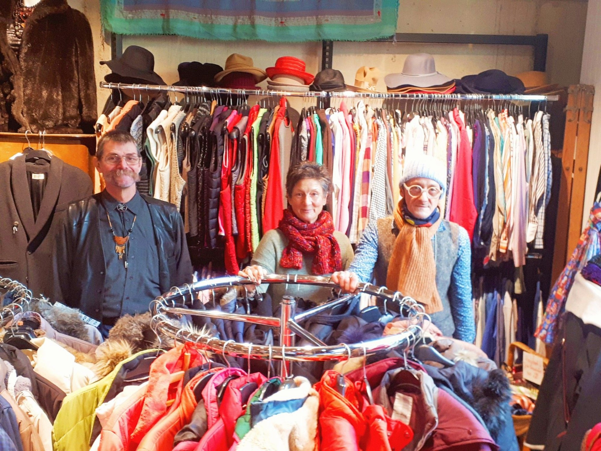 Das Verkaufsteam des Bella Flora steht im Laden. Vor und hinter ihnen hängt Kleidung.