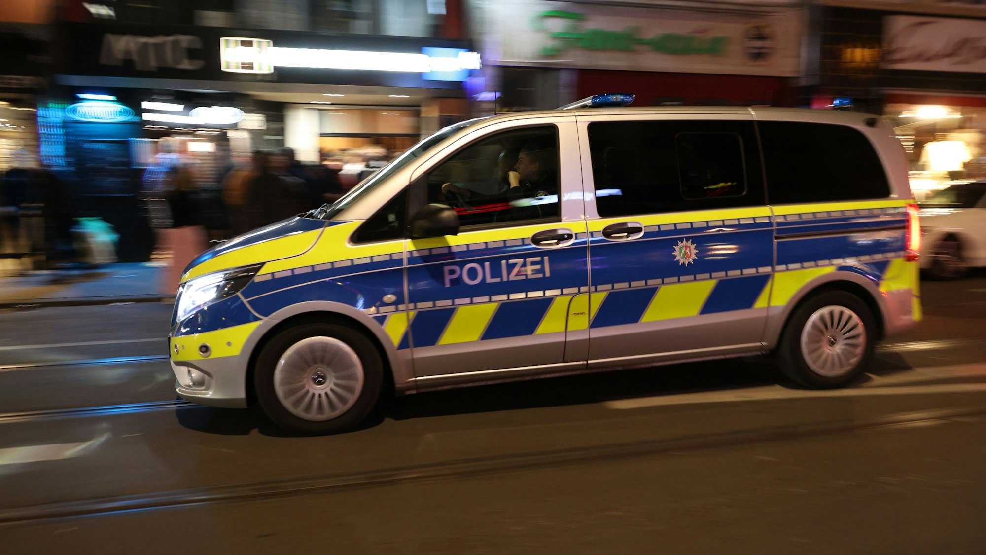Ein Polizeiauto fährt in der Nacht durch Köln (Symbolfoto)