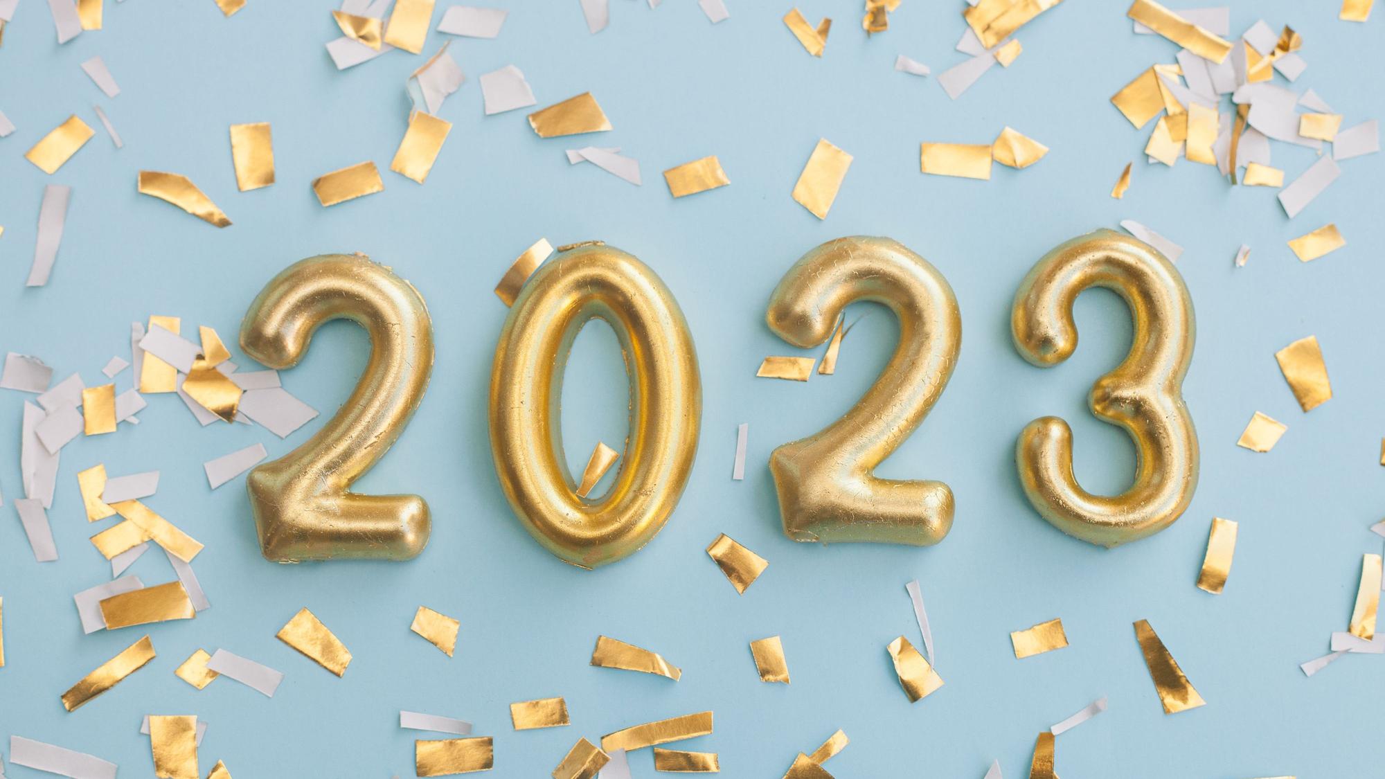 Der Schriftzug 2023 mit Konfetti auf blauem Hintergrund