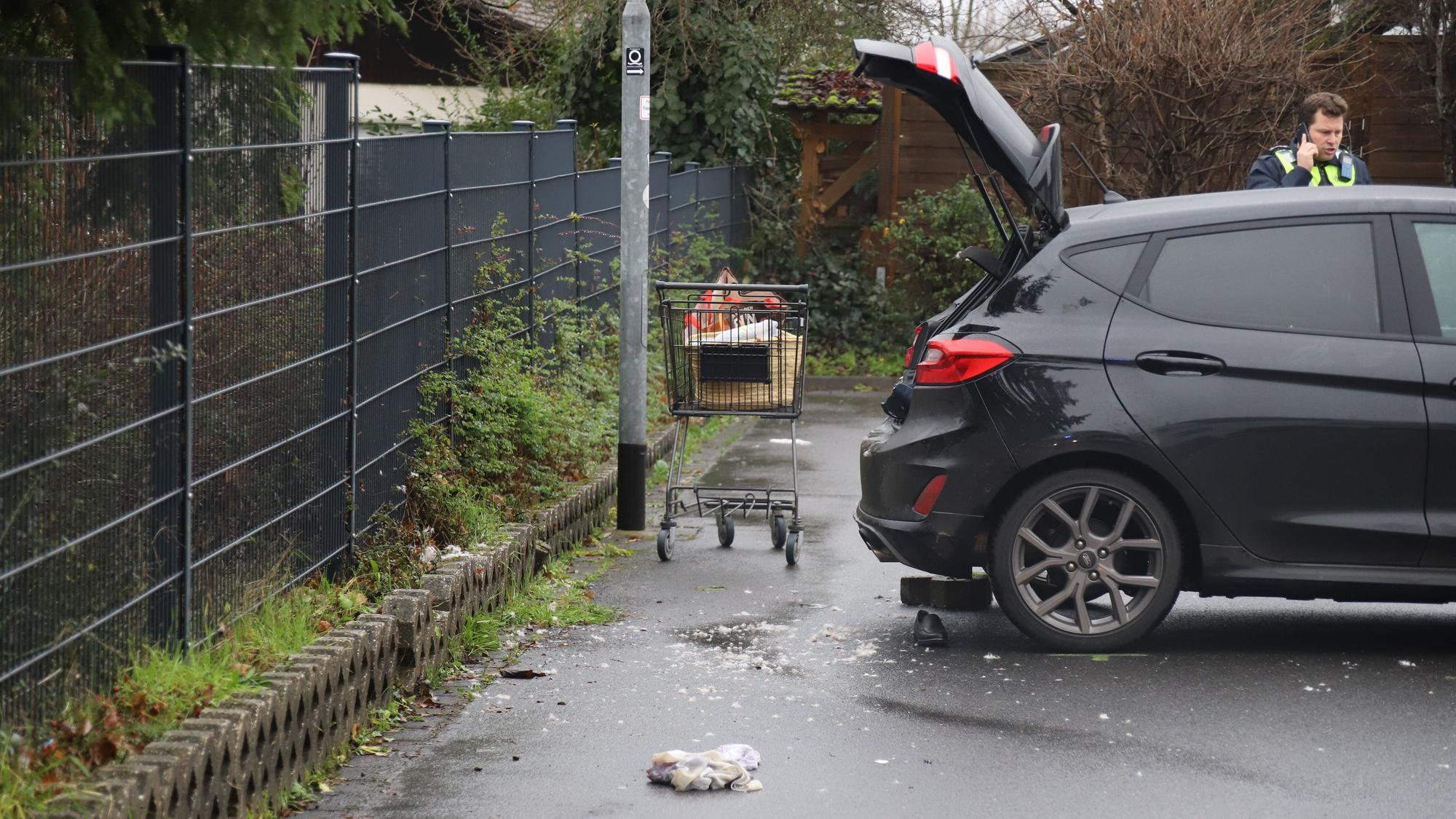 Nach einem Unfall steht der verlassene Einkaufswagen einer Frau hinter dem Fahrzeug.