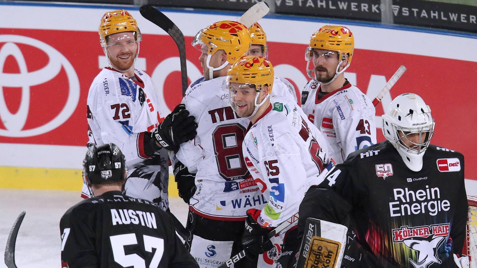 Spieler der Kölner Haie lassen die Köpfe hängen, Bremerhavener Spieler jubeln.