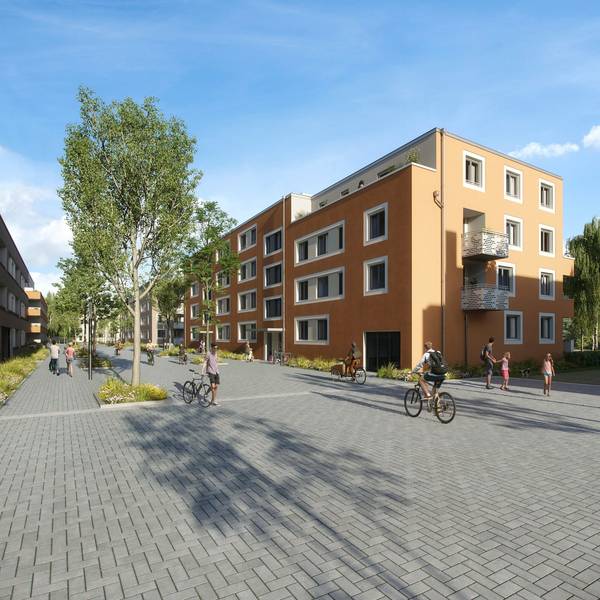 Neue Wohnblöcke und eine Straße mit Fußgängern und Radfahrern sind zu sehen.