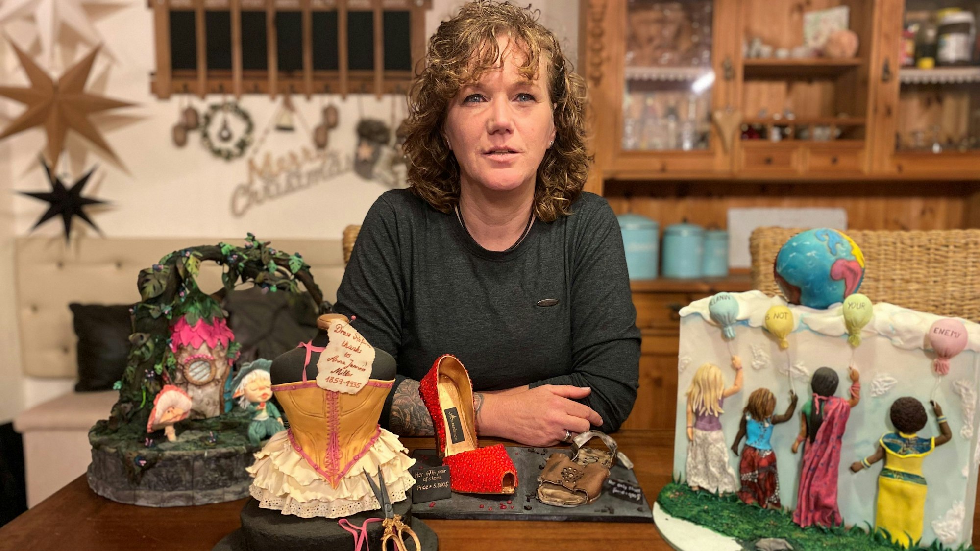 Doreen Zilske sitzt an einem Tisch, auf dem einige ihrer Kunstwerke stehen.