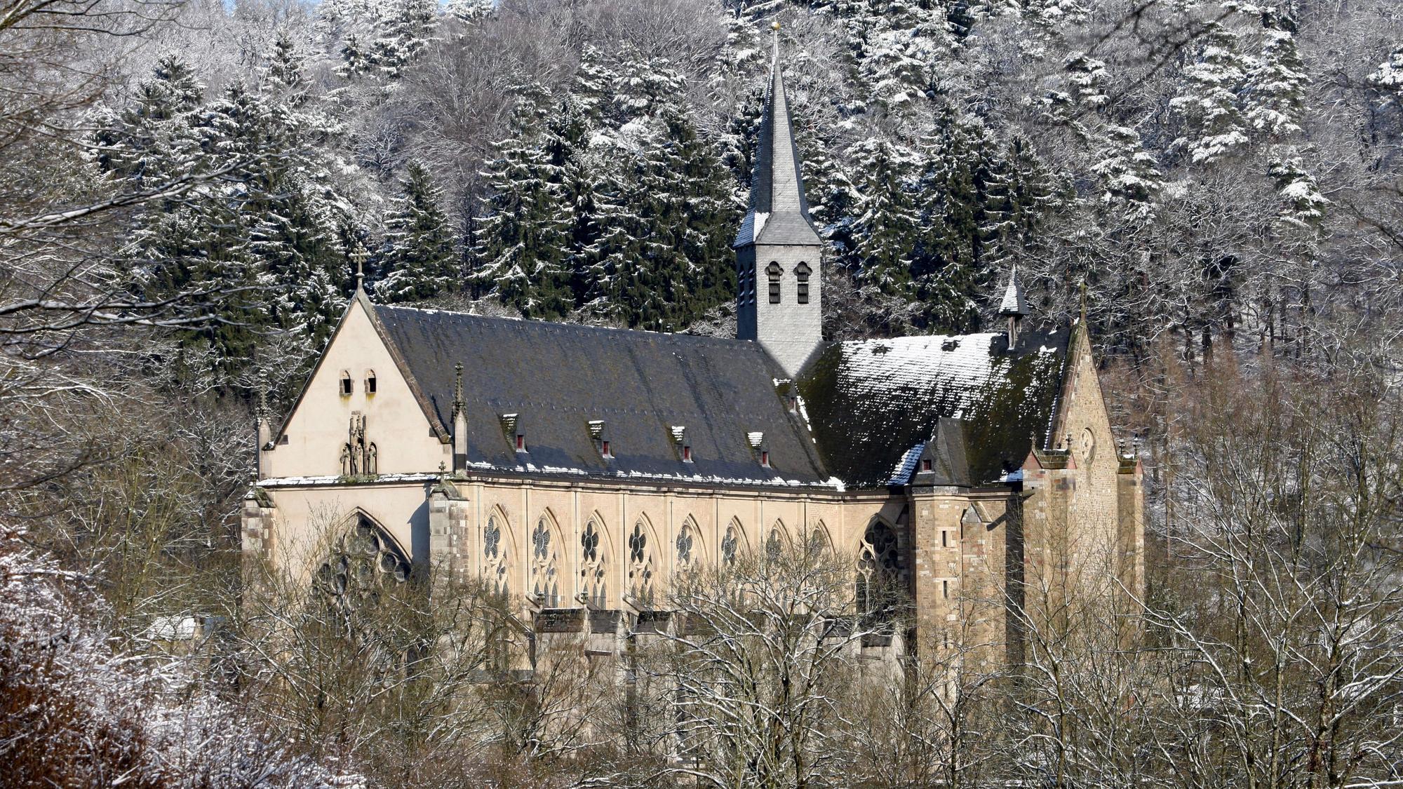 Der Altenberger Dom im Schnee, umgeben von schneeverzuckerten Bäumen.
