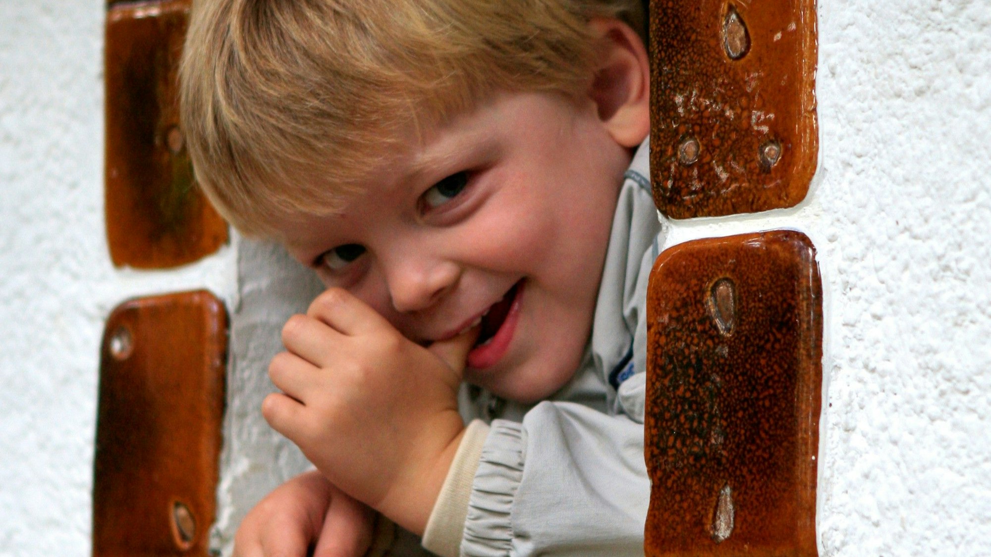 Ein Kind schaut aus dem Fenster eines Knusperhauses.