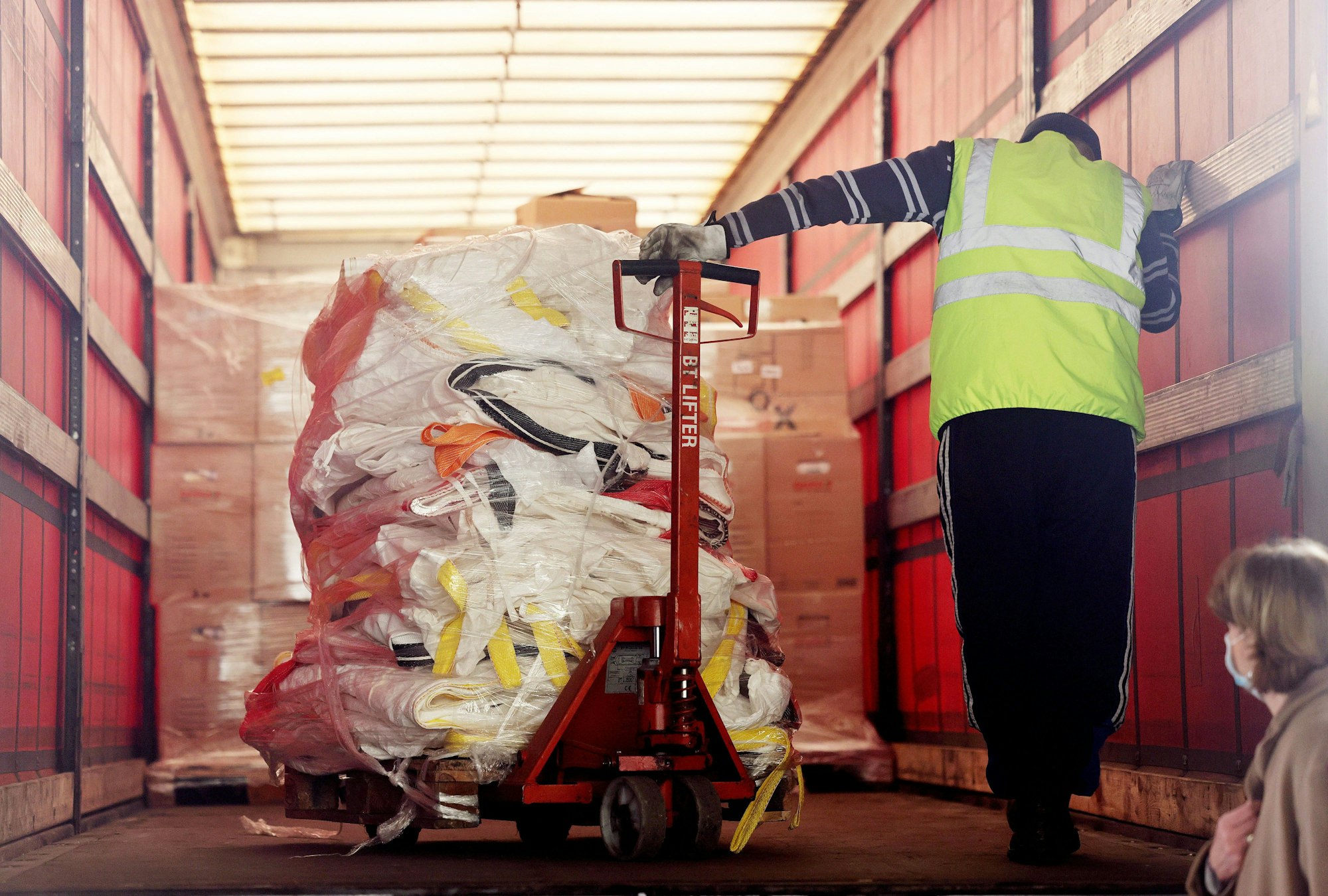 Ein Arbeiter verlädt Paletten mit Hilfsgütern.