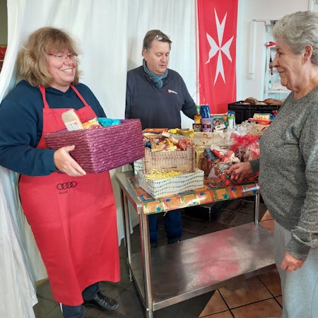 Malteser Tafel: Das Bild zeigt Petra Drehert und Gerhard Kunst, die die Tafel an der Steinstraße 6 leiten, mit einer Kundin.