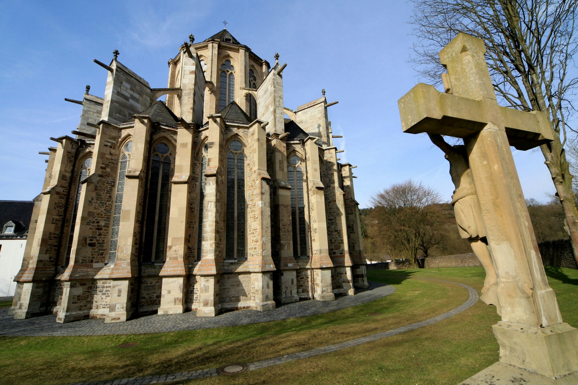 Ein Kreuz steht hinter der dem Chor des Altenberger Doms.