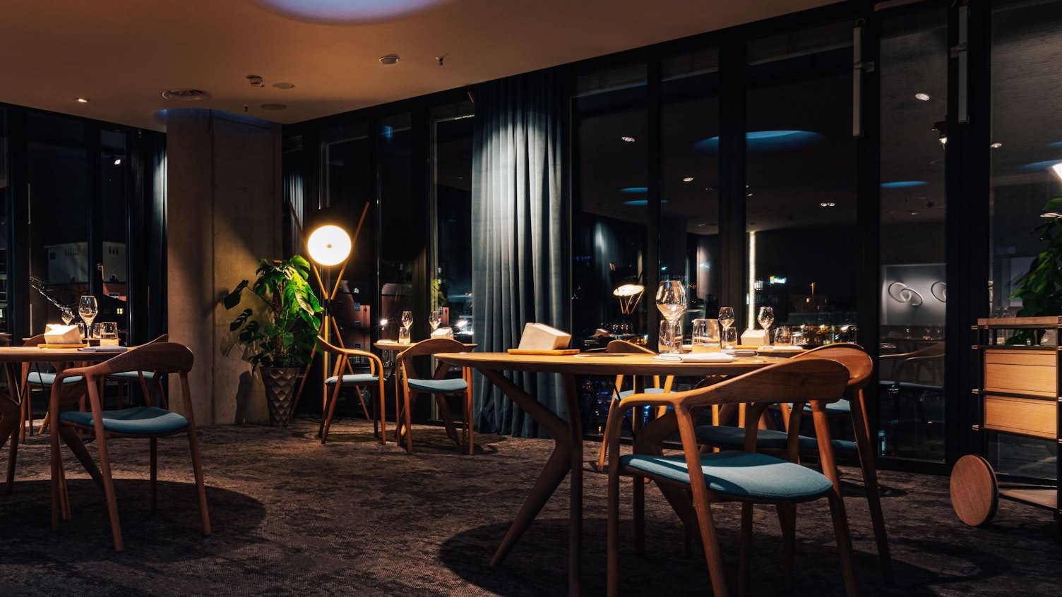 Ein dunkler Teppich, helle Holzmöbel dominieren den Anblick des Gastraums im Ox & Klee