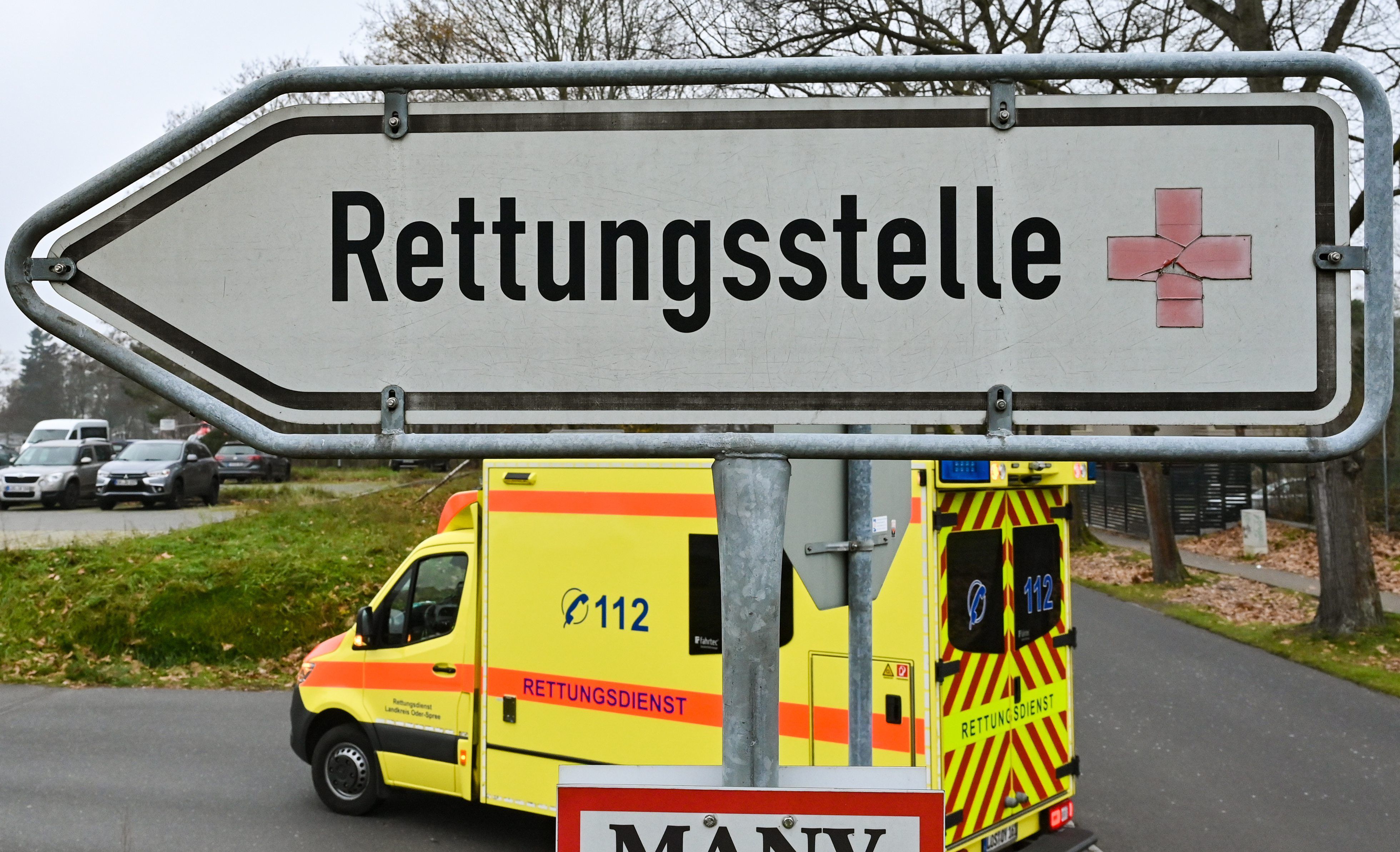 Hinter einem Schild mit der Aufschrift „Rettungsstelle“ fährt ein Krankenwagen.