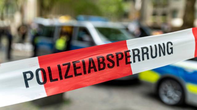 Ein Polizeiwagen steht hinter einer Absperrung.