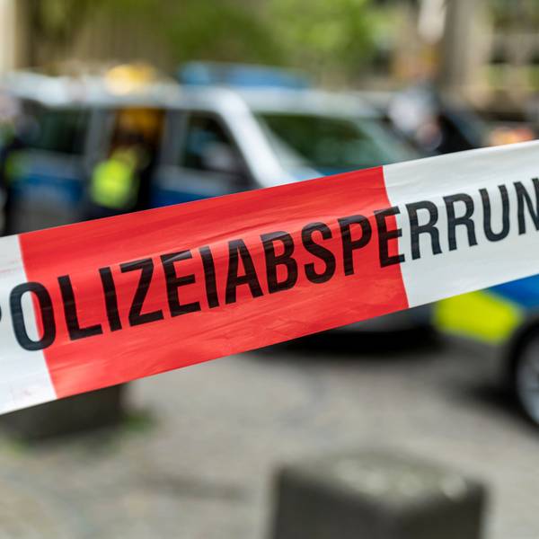 Ein Polizeiwagen steht hinter einer Absperrung.