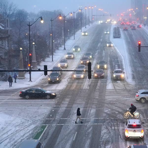 Fußgänger gehen über glatte Straßen. Ein arktisches Sturmtief bringt über die Weihnachtstage drastische Temperaturstürze und extreme Kälte in die USA.