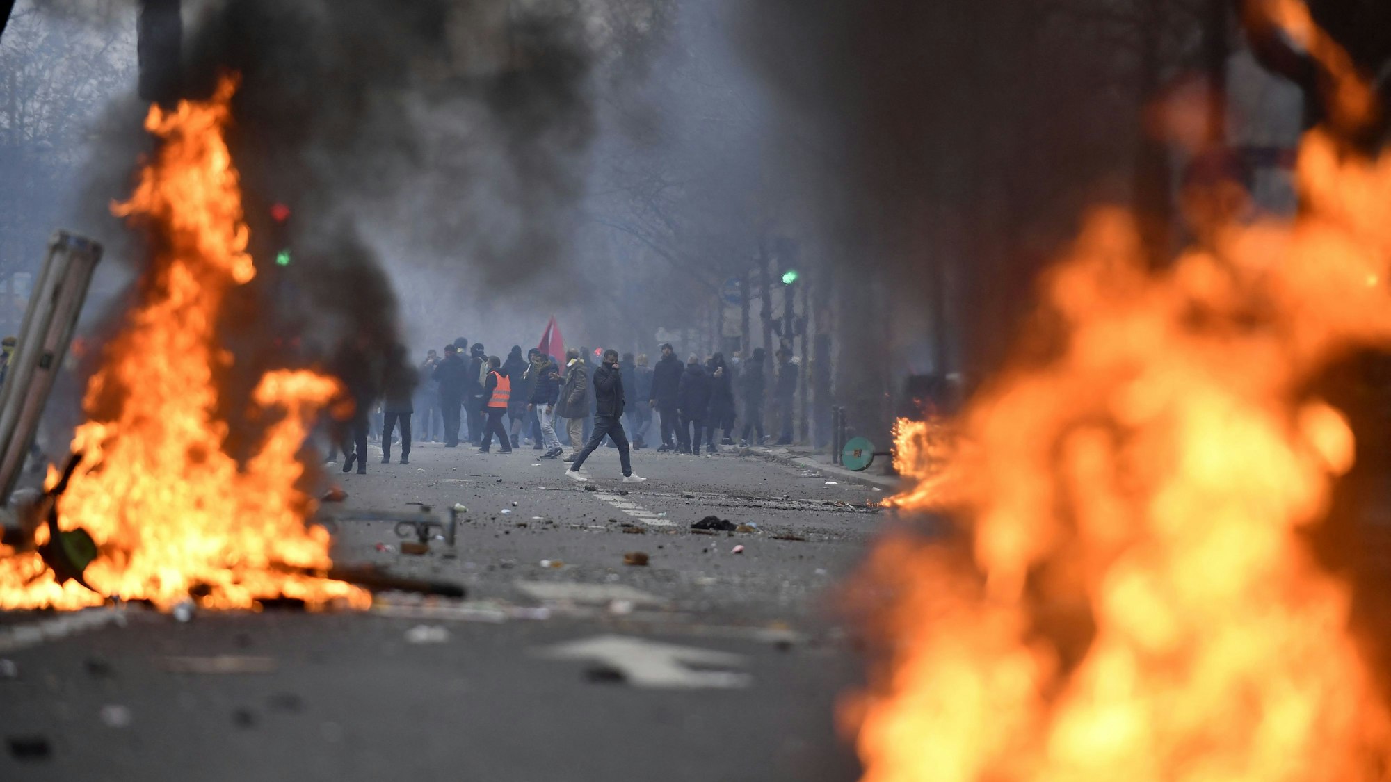 Protestierende stehen hinter Flammen.
