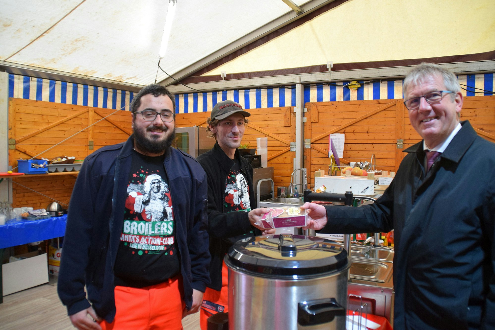 Der Bürgermeister übergibt Plätzchen an die Helfer.