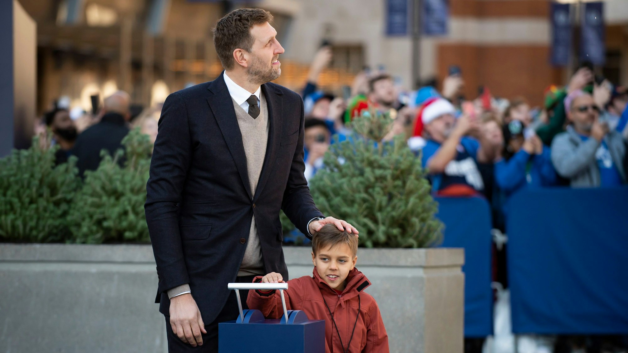 Dirk Nowitzki, hier mit seinem Sohn Max, schaut beeindruckt auf sein riesiges in Stein gemeißeltes Abbild.