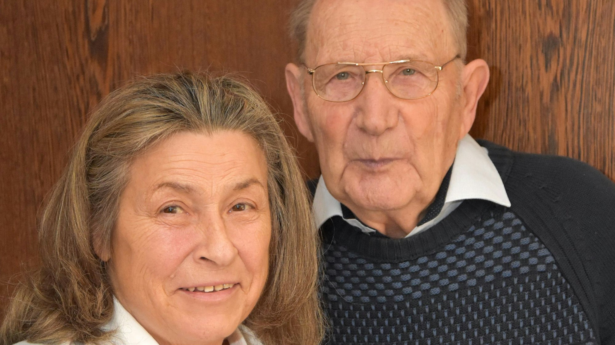 Ein älteres Ehepaar lächelt in die Kamera.