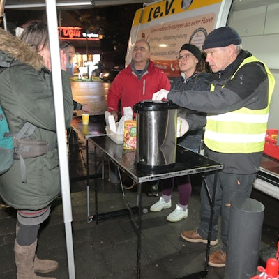 Ali Misini steht vor dem Kältebus und verteilt Essen.