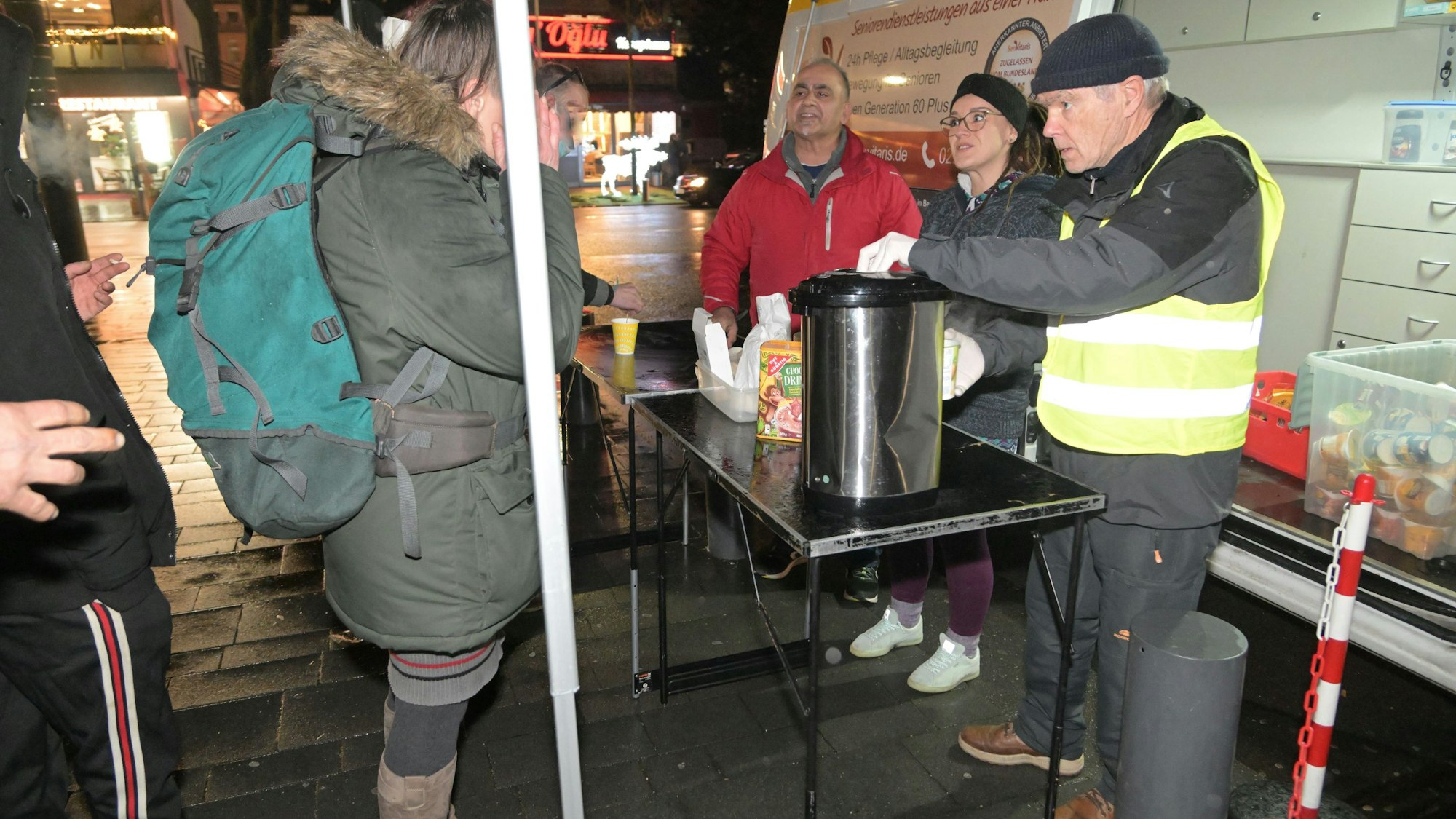 Ali Misini steht vor dem Kältebus und verteilt Essen.