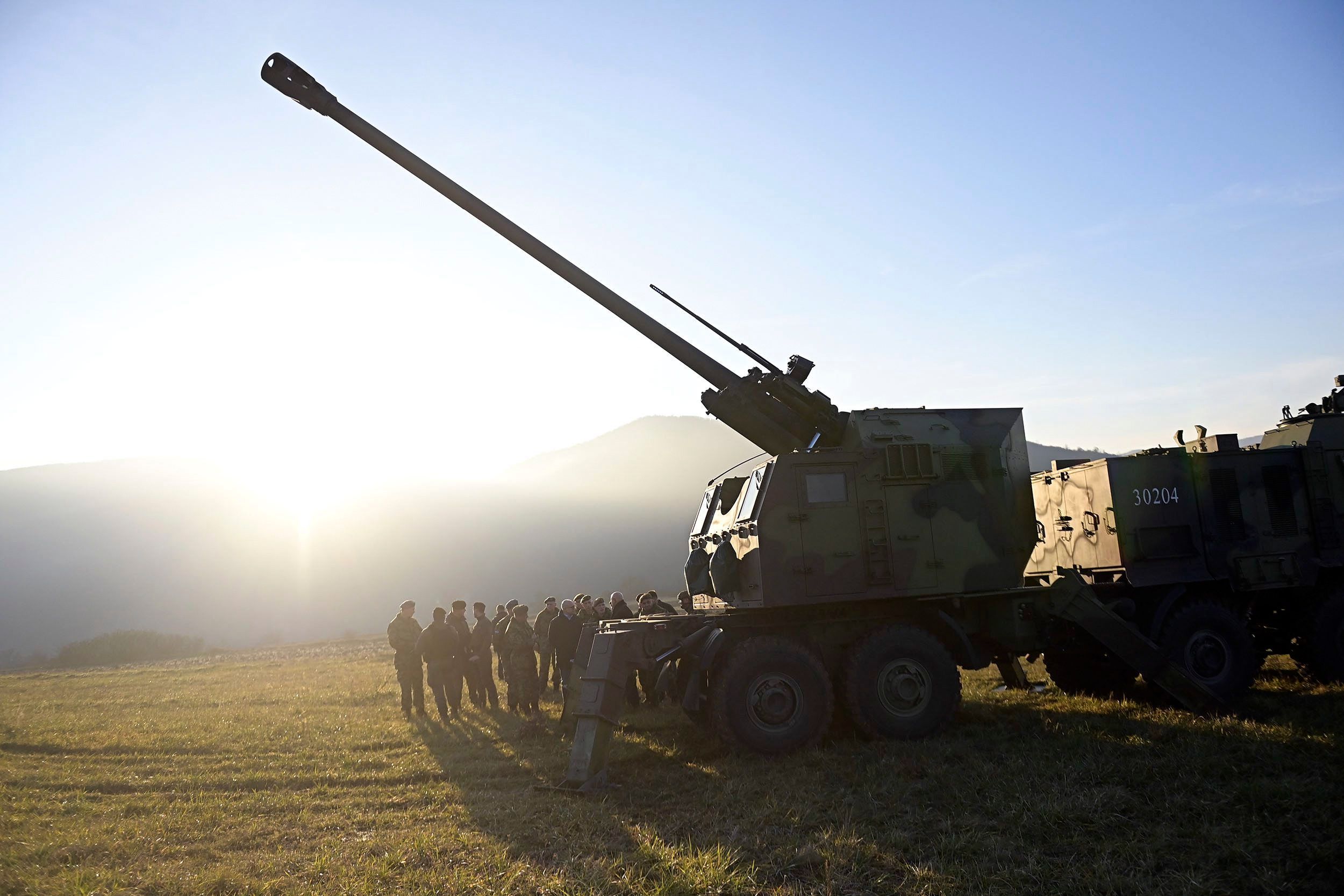 Es ist die serbische Armee mit einer Haubitze auf einem Feld zu sehen.