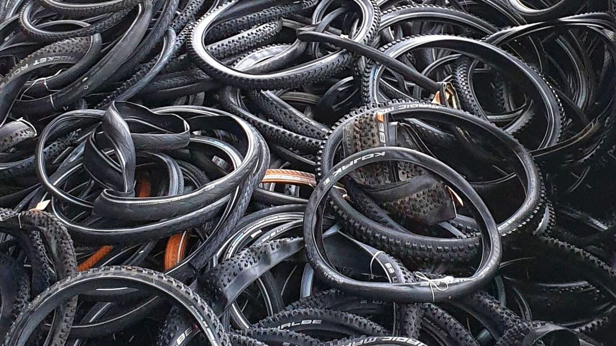 Viele Fahrradreifen liegen auf einem Haufen.