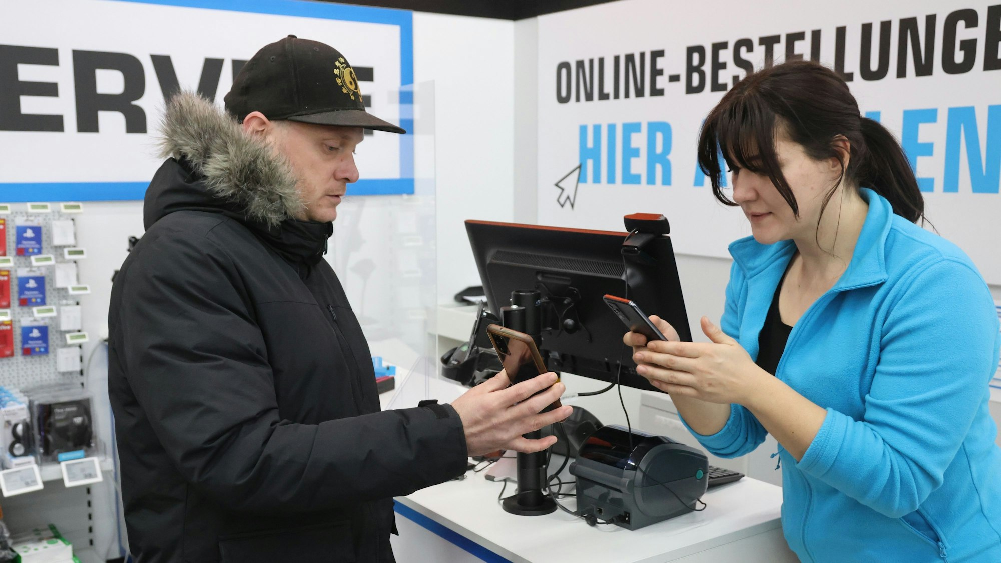 Ein Mann und eine Frau halten ihre Handys aneinander.