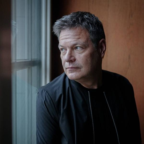 Man sieht Robert Habeck an einem Fenster. Er lehnt mit dem Rücken an der Wand und schaut durch das Fenster.