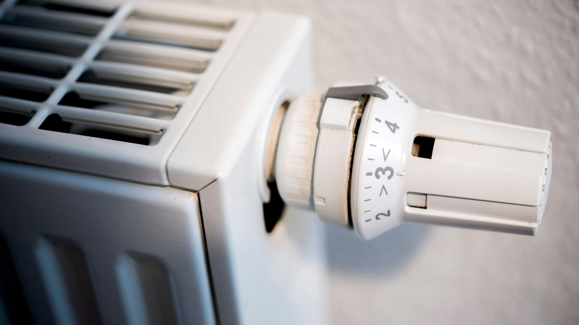 Ein Heizkörper hängt in einer Wohnung an einer Wand.