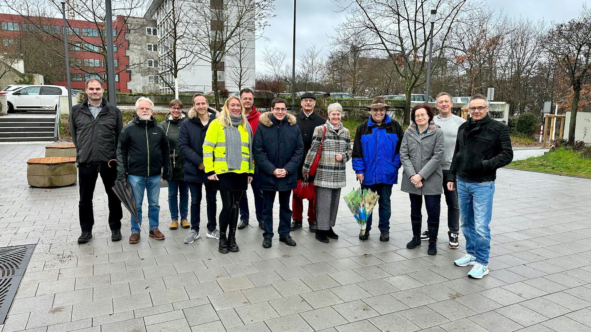 Einige Menschen stehen auf einem Schulhof in Sankt Augustin.