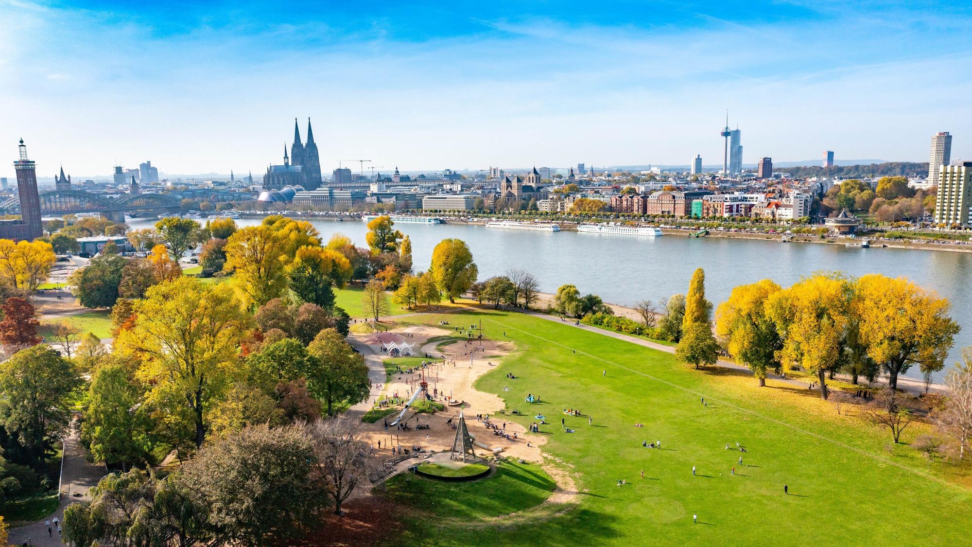 Blick auf den Rheinpark mit Spielplatz am Rhein in Köln.