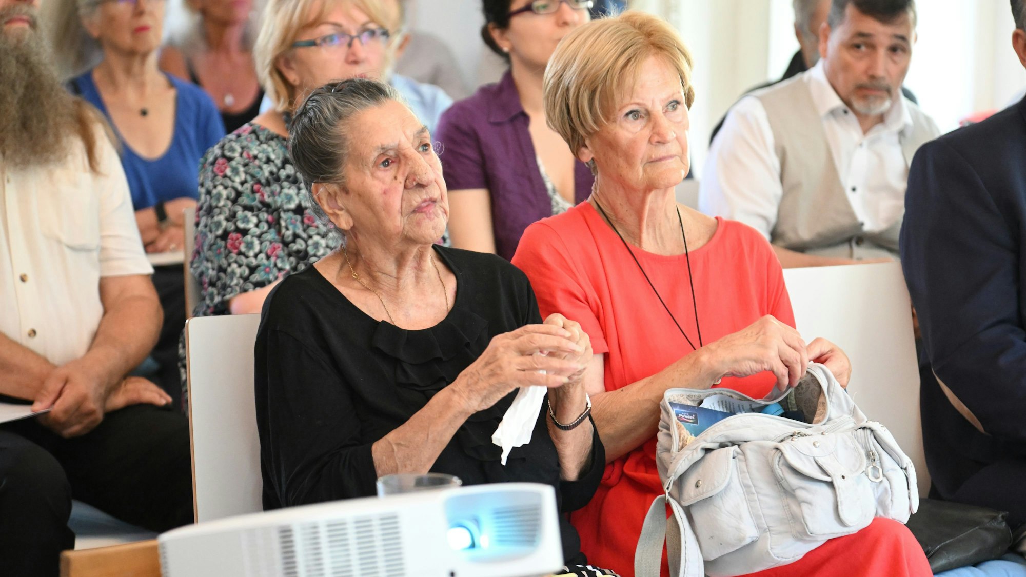 Philomena Franz sitzt und hört auf dem Empfang zu ihrem 100. Geburtstag im Juli 2022 auf Schloss Eulenbroich in Rösrath einem Redner zu.