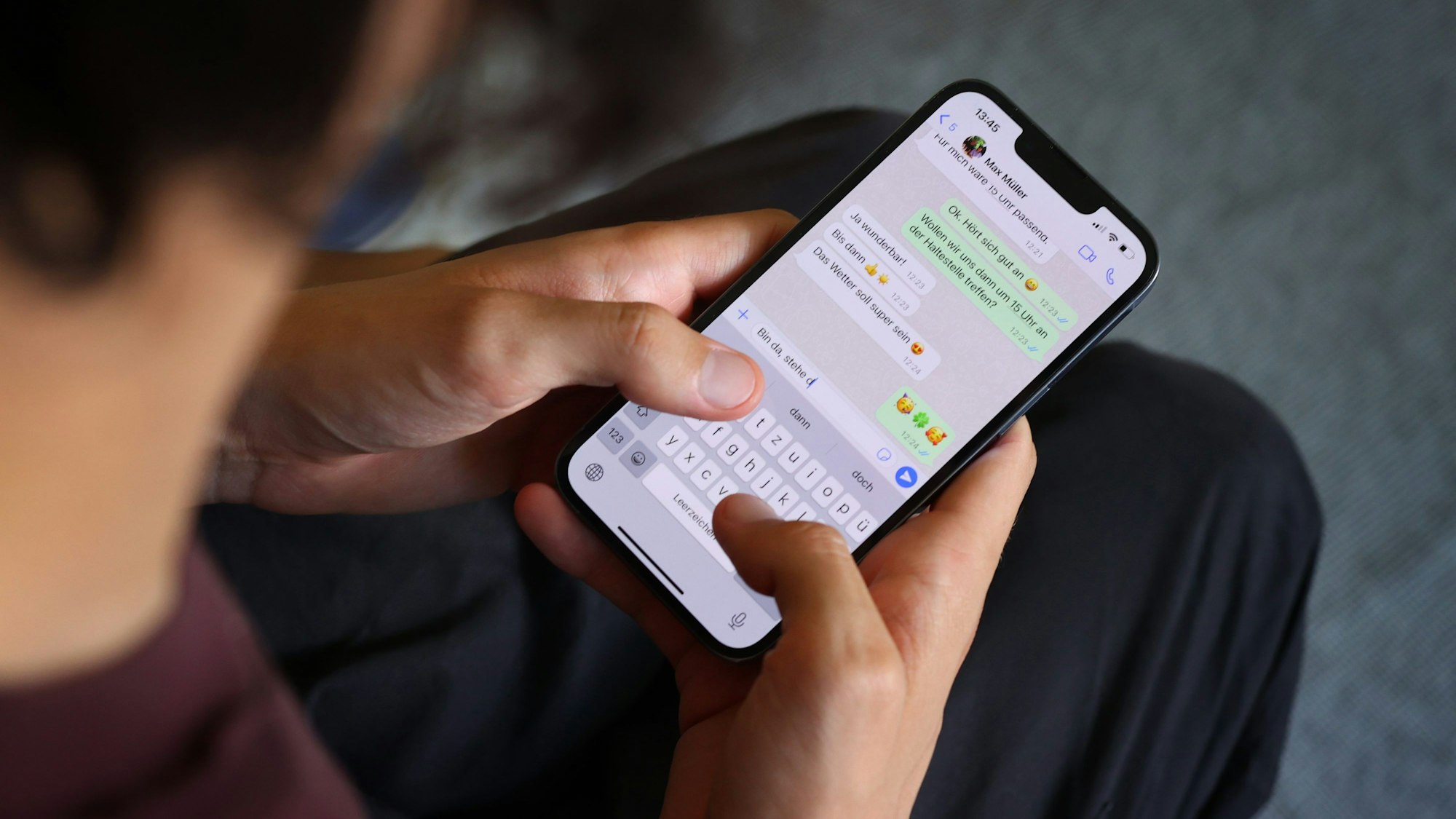 Zwei Hände tippen eine Nachricht in ein Smartphone.