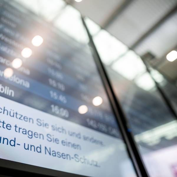 Auf einer Anzeigetafel steht der Hinweis «Schützen Sie sich und andere. Bitte tragen Sie einen Mund- und Nasen-Schutz».