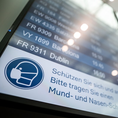 Auf einer Anzeigetafel steht der Hinweis «Schützen Sie sich und andere. Bitte tragen Sie einen Mund- und Nasen-Schutz».