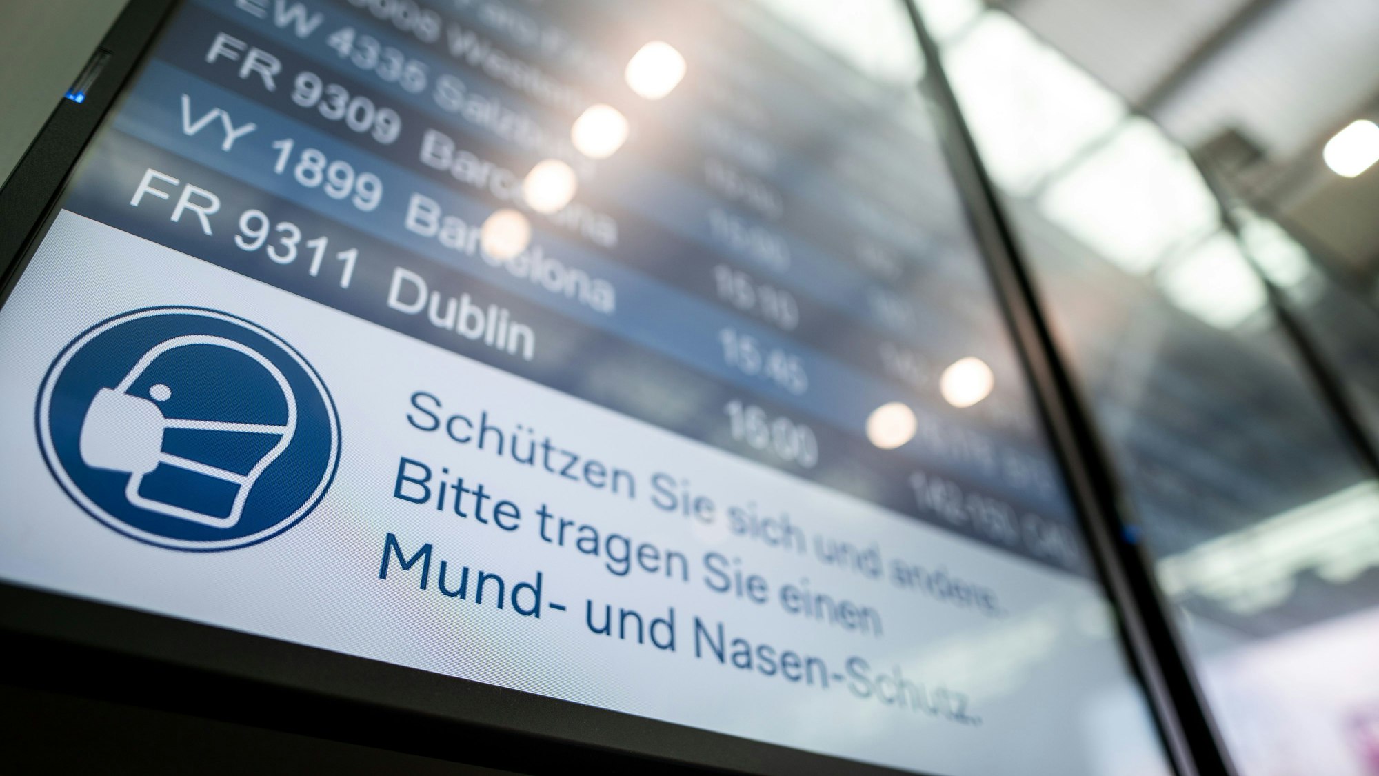 Auf einer Anzeigetafel steht der Hinweis «Schützen Sie sich und andere. Bitte tragen Sie einen Mund- und Nasen-Schutz».