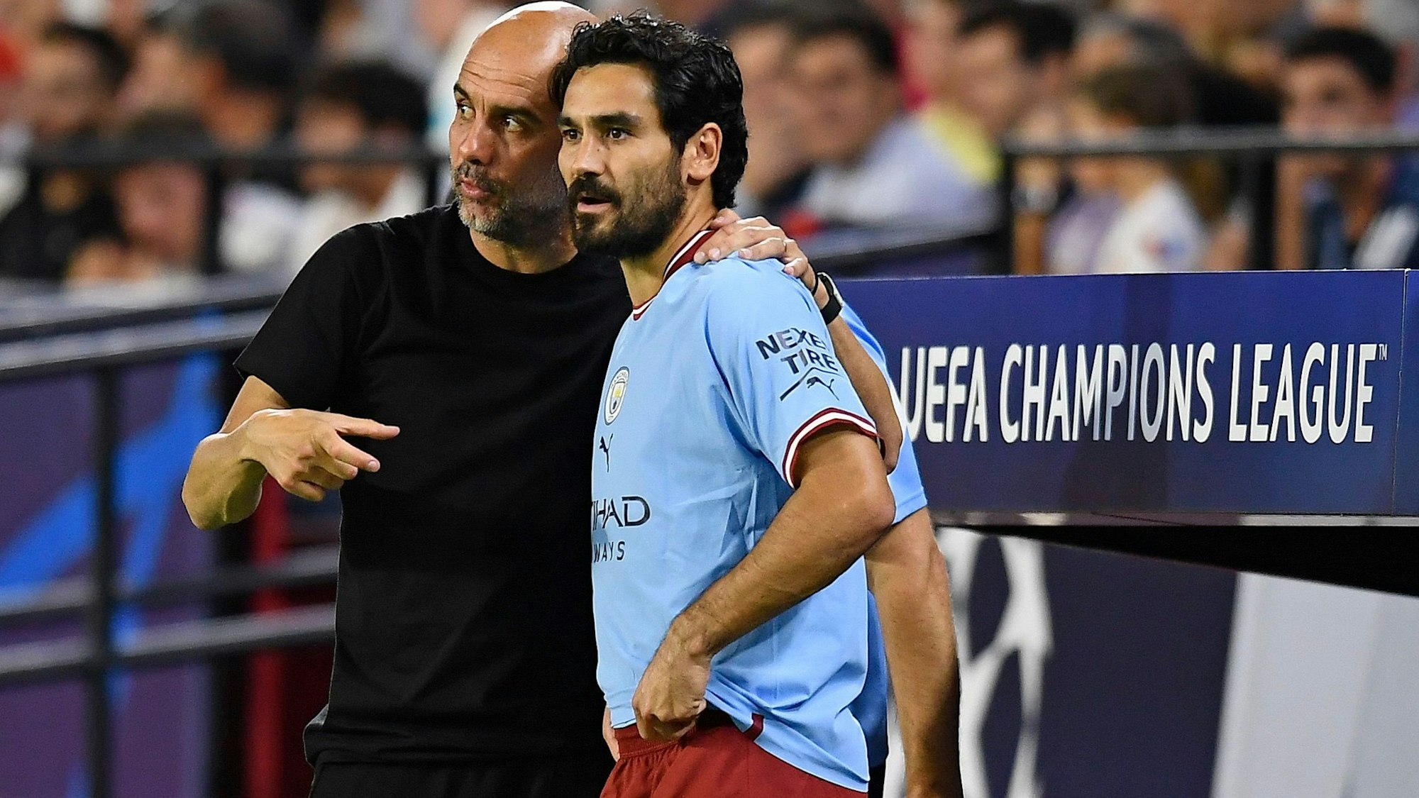 Ilkay Gündogan steht mit Manchester Citys Cheftrainer Pep Guardiola an der Seitenlinie während eines Spiels.