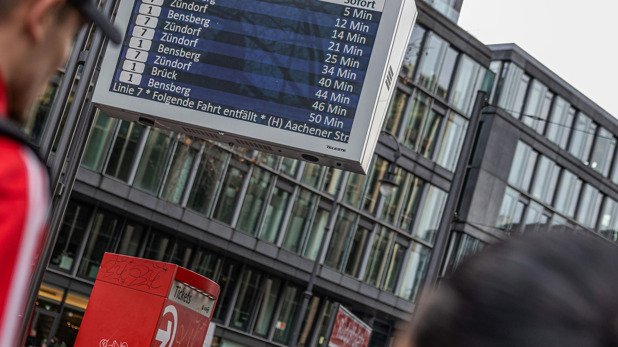 Ein Infoterminal der KVB an einem Bahnsteig, auf dem die Wartezeiten und die entfallenden Verbindungen aufgelistet sind.