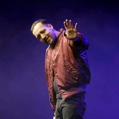 Rapper Danger Dan winkt auf seinem Konzert im Theater am Tanzbrunnen Köln in die Kamera.