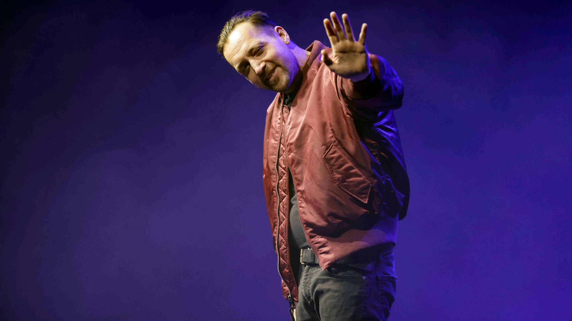 Rapper Danger Dan winkt auf seinem Konzert im Theater am Tanzbrunnen Köln in die Kamera.