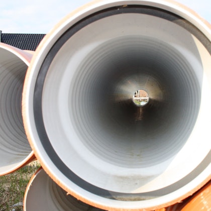 Abwasserrohre liegen auf einer Baustelle.