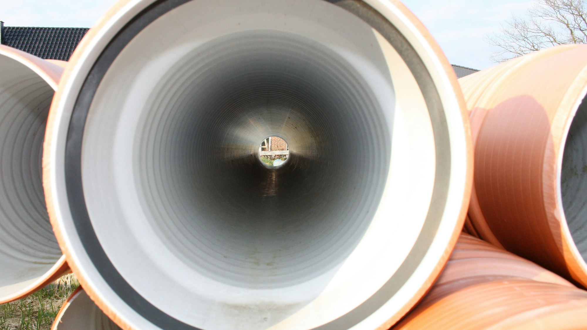 Abwasserrohre liegen auf einer Baustelle.