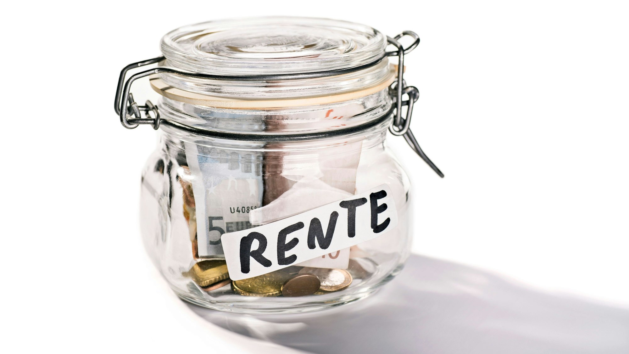 Ein Glas mit der Aufschrift „Rente“. In dem Glas ist Geld.