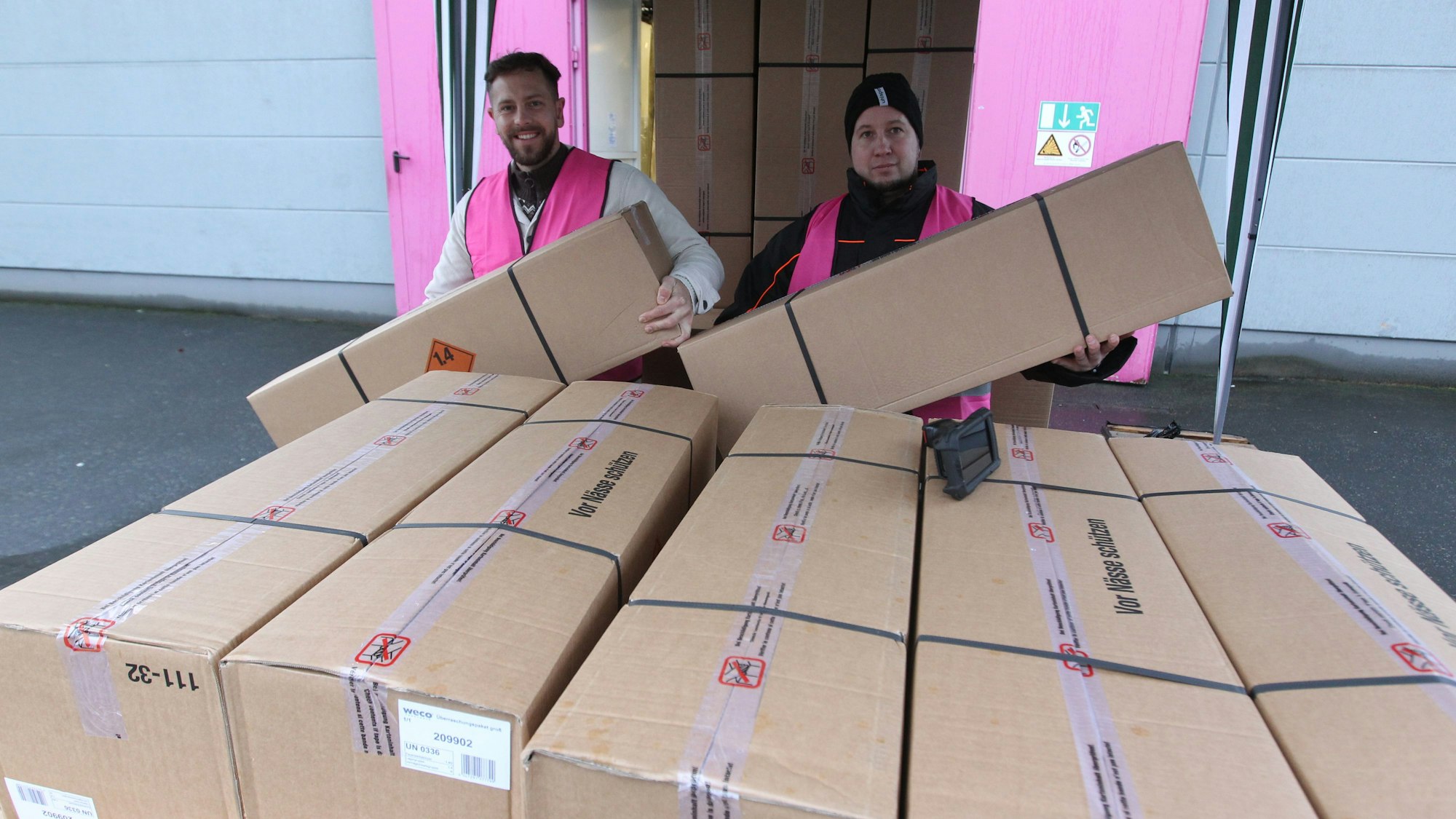 Zwei Weco-Mitarbeiter halten die gut ein Meter langen Überraschungspakete.